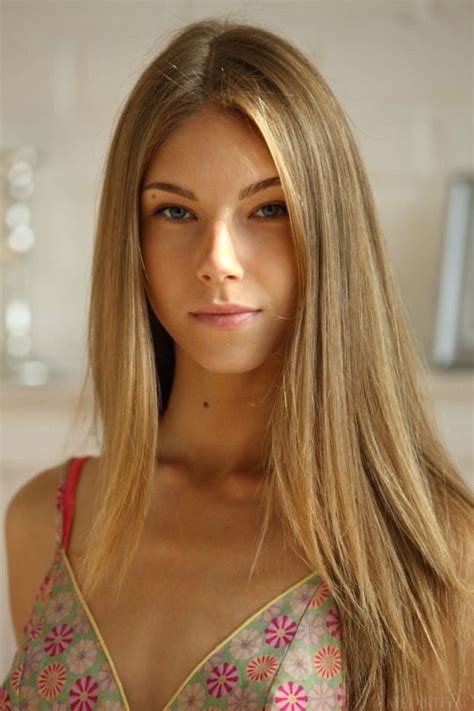 A Woman With Long Blonde Hair Is Looking At The Camera