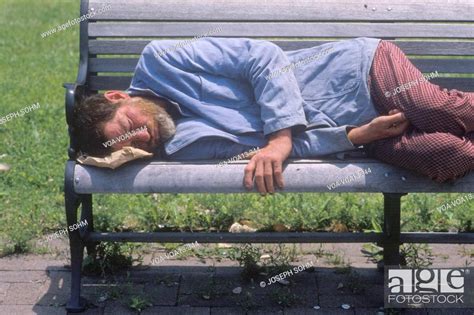 Homeless Man Sleeping On A Park Bench Los Angeles California Stock