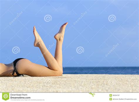 Beautiful Smooth Model Legs Resting On The Sand Of The Beach Stock