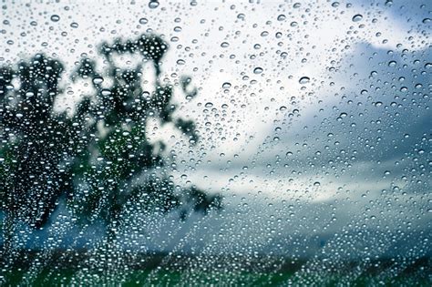Drops Of Rain On The Window Blurred Trees And Storm Clouds In The