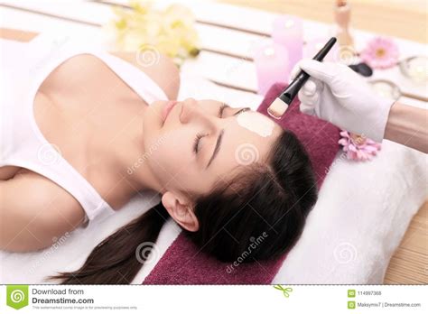 Spa Therapy For Young Woman Receiving Facial Mask At Beauty Salon