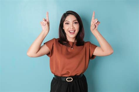 Mulher Asiática Excitada Vestindo Camisa Marrom Apontando Para O Espaço De Cópia Acima Dela