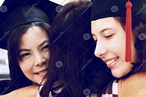 Close Up Portrait Of Two Girls In Graduation Gown Graduation Day Stock