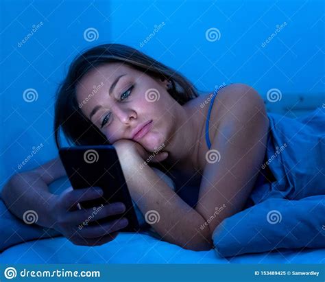 attractive woman addicted to mobile phone late at night in bed l stock image image of dating