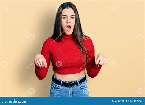Jovem Adolescente Morena Vestindo Camisola Vermelha De Gola De Gola Alta Apontando Para Baixo