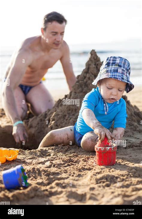 Father And Son Playing With Sand At The Beach Stock Photo Alamy