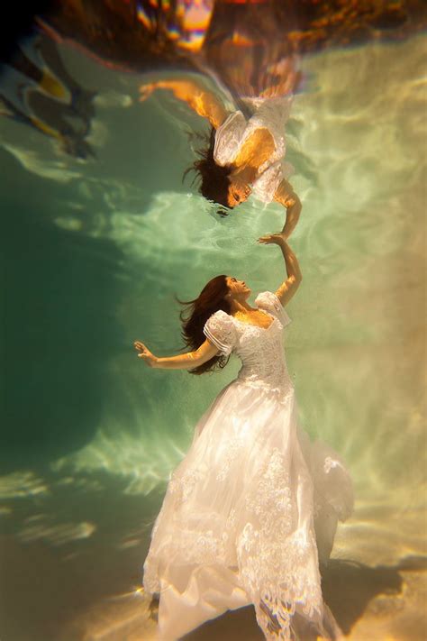 Two Women In White Dresses Are Under Water