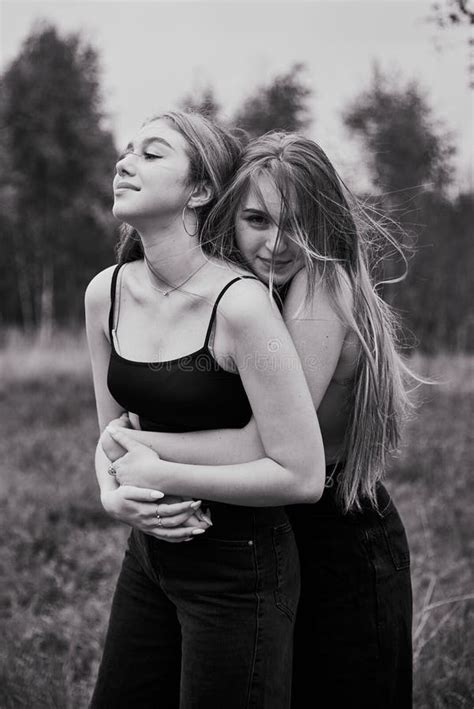 Two Teenage Girls With Long Hair On A Walk Hug Each Other Stock Image