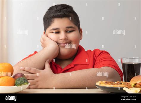 Young Boy Looking Happily At The Junk Food Obesity Stock Photo Alamy