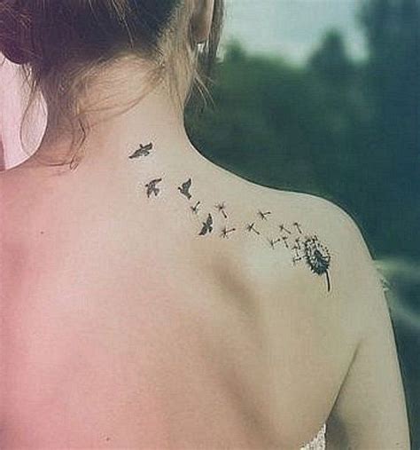 the back of a woman s shoulder with a dandelion tattoo