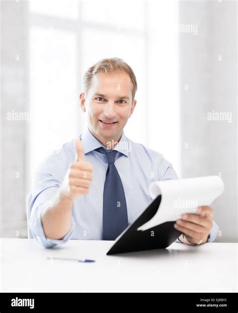 Businessman With Papers Showing Thumbs Up Stock Photo Alamy