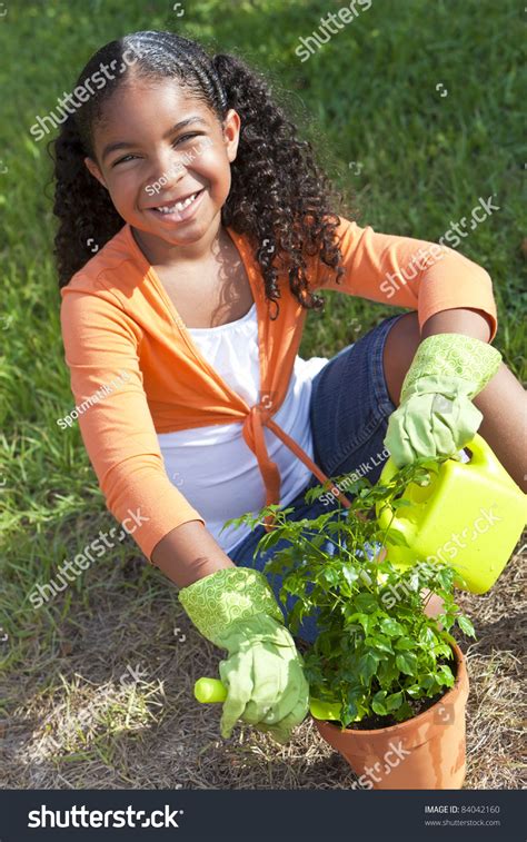 Happy African American Girl Child Gardening Planting Flowers And