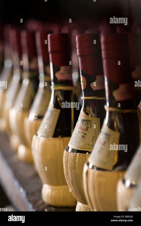 Chianti Classico Red Wine Bottles Wrapped In Straw On A Rack Stock