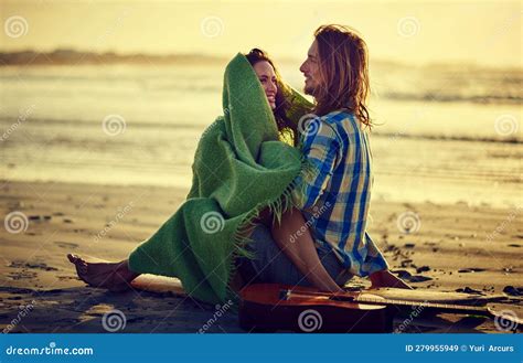 we grow closer and stronger each day a couple sitting on the beach with their legs intertwined