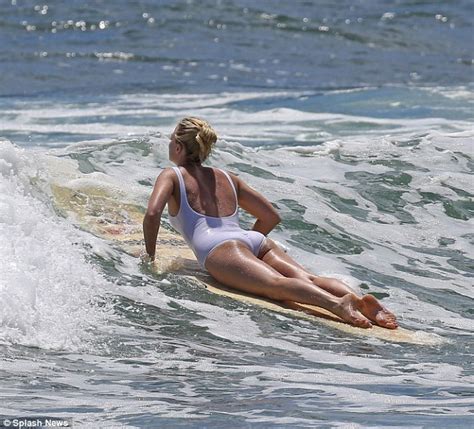 Margot Robbie Manages A Stylish Wipe Out Surfing In A White One Piece