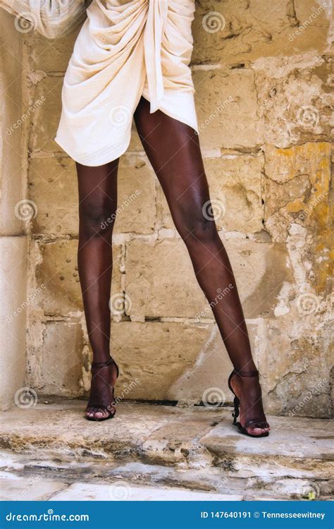 Legs Of A Black African Model Posing In The Street Against A Wall Stock