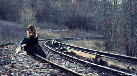 Girl Sitting On Railway Tracks