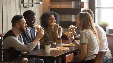 Smiling Multiracial Friends Eating Pizza And Drinking Coffee Laughing And Having Fun In