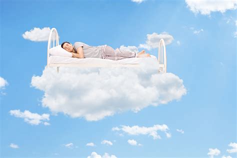 A Man Sleeping In A Bed Of Clouds Stock Photo Download Image Now Istock