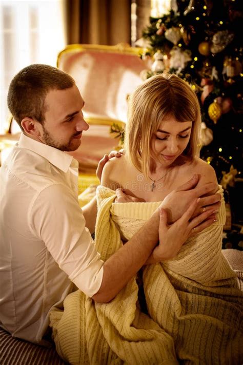Loving Young Couple Spends Christmas At Home Near A Decorated Festive