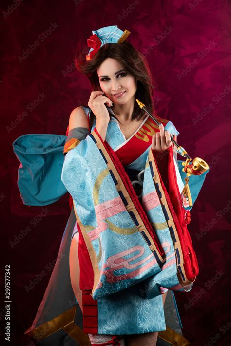 Beautiful Leggy Busty Cosplayer Girl Wearing A Stylized Japanese Kimono Costume Cheerfully