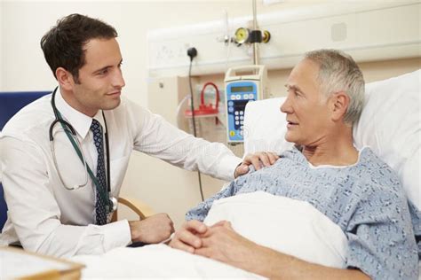 Doctor Sitting By Male Patient S Bed In Hospital Stock Image Image Of