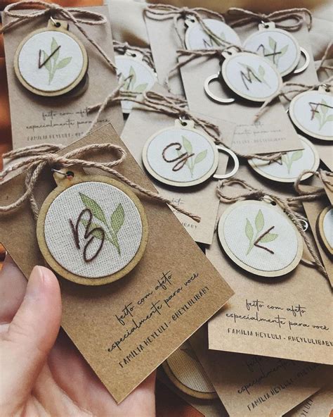 A Person Holding Up Some Tags That Have Flowers On Them And The Letters