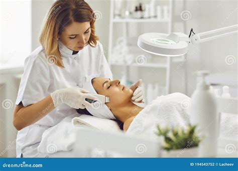 Young Cosmetologist Or Dermatologist Making Ultrasound Facial Cleaning