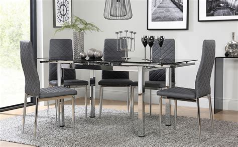 Black dining tables and gray fabric chairs create a modern and elegant look under the bubble lighting. Space Chrome and Black Glass Extending Dining Table with 4 ...