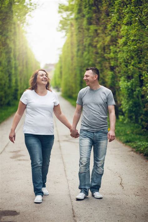 Happy Loving Couple On A Romantic Walk Outdoors In Park Stock Image