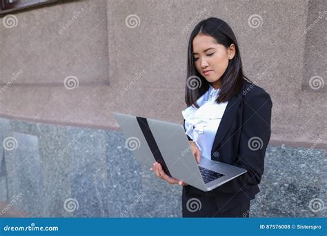 Beautiful Young Girl Entrepreneur Holds Laptop And Works Solves Stock