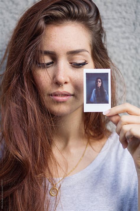 Young Woman Holding Her Polaroid Portrait By Stocksy Contributor