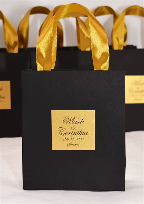Four Black Bags With Gold Ribbons On Them