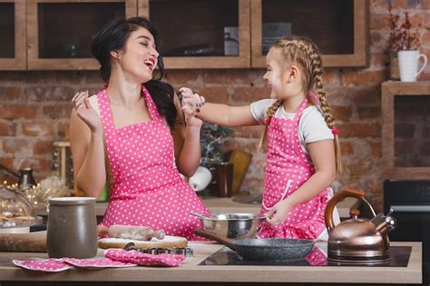Premium Photo Young Beautiful Mother And Her Little Daughter Cooking Together At The Kitchen
