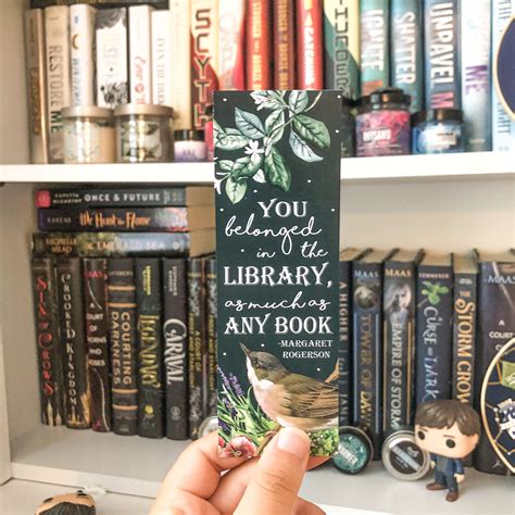 Someone Is Holding Up A Bookmark In Front Of Some Bookshelves And Shelves