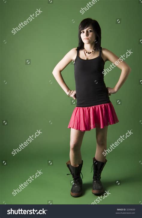 Teen Girl Standing With Hands On Hips Wearing Skirt And Galoshes Stock