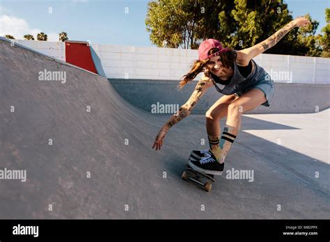 Skater Female Rides On Skateboard At Skate Park Ramp Young Woman