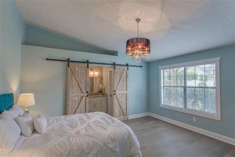 Traditional Master Bedroom With Hardwood Floors And Barn