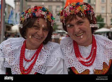 Two Polish Women In Traditional Costumes And Beaded Headresses Are