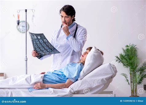 El Doctor De Sexo Masculino Que Visita Al Paciente Femenino En Sala Foto De Archivo Imagen De