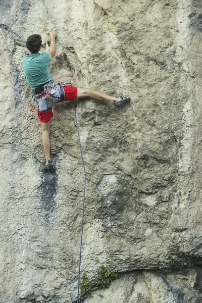 Rock Climber Ascending A Challenging Cliff Extreme Sport Climbi