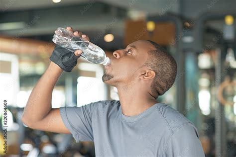 Black Man Drinking Water From Bottle In Gym Serious Black Guy Wearing