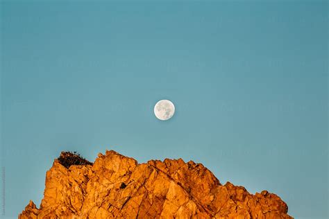 Full Moon Setting At Sunrise Over Rocky Ledge By Stocksy Contributor