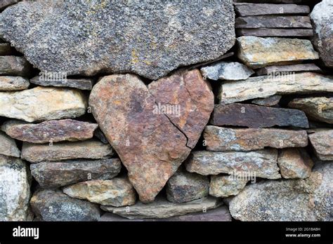 A Heart Shaped Stone Stuck In The Middle Of A Wall With Other Small And