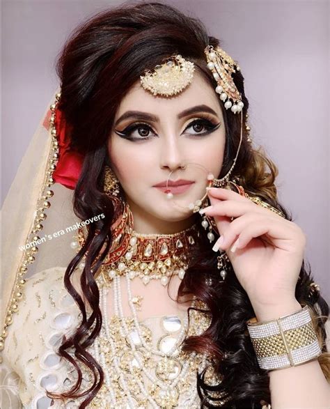 a woman wearing a bridal outfit and jewelry