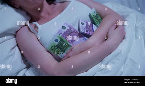 Woman Sleeping On Bed With Bundle Of Currency Notes Stock Photo Alamy