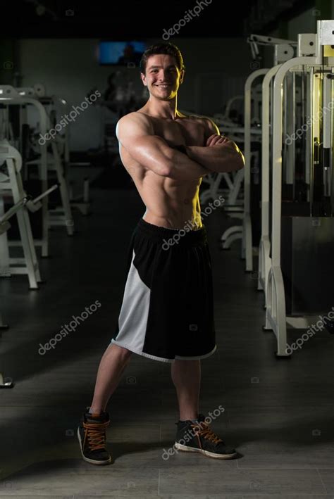 Muscular Man Flexing Muscles In Gym — Stock Photo © Ibrak 114340174