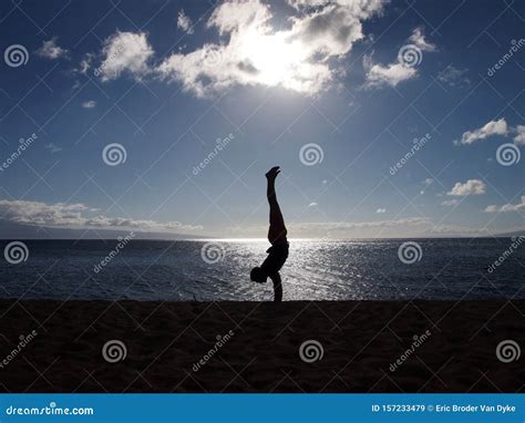 Silhouette Of Man Handstands At Sunset On An Empty Beach Stock Image