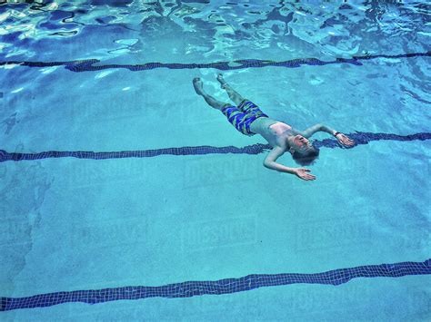 Caucasian Boy Floating In Swimming Pool Stock Photo Dissolve