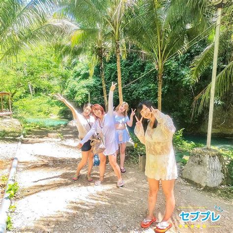 four girls are posing for a photo in front of some trees